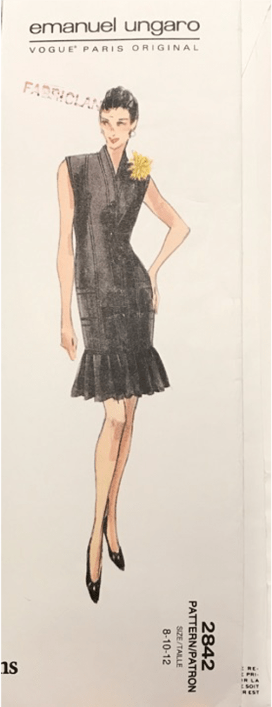 The drawing of the dress from the pattern. It is sleeveless with a kimono collar and a sharply creased flounce that hits mid thigh. 