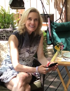 Jennifer seated in dappled shade wearing the dress