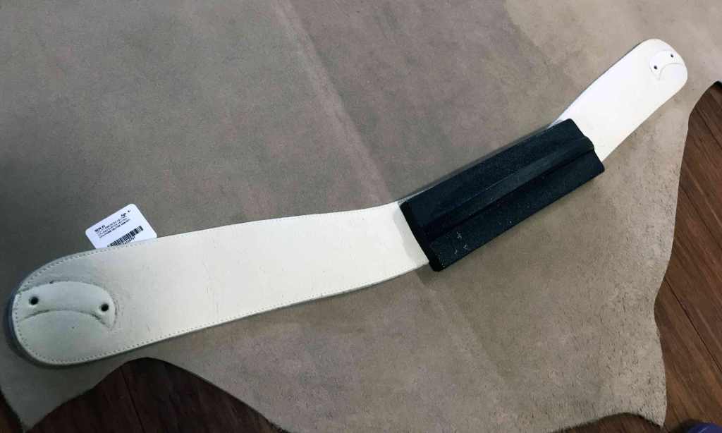 old belt laid out on leather hide