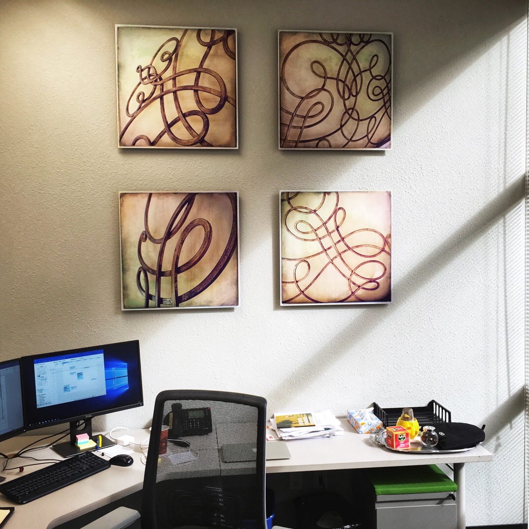 4 photographs printed on metal hang above a client's office desk