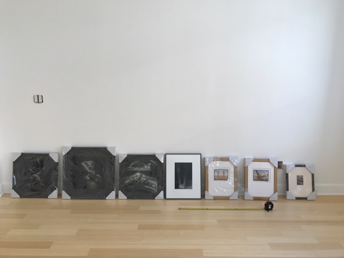 7 framed and wrapped photographs that are the best of 20 years of photographic work by me sit on the floor waiting to be hung