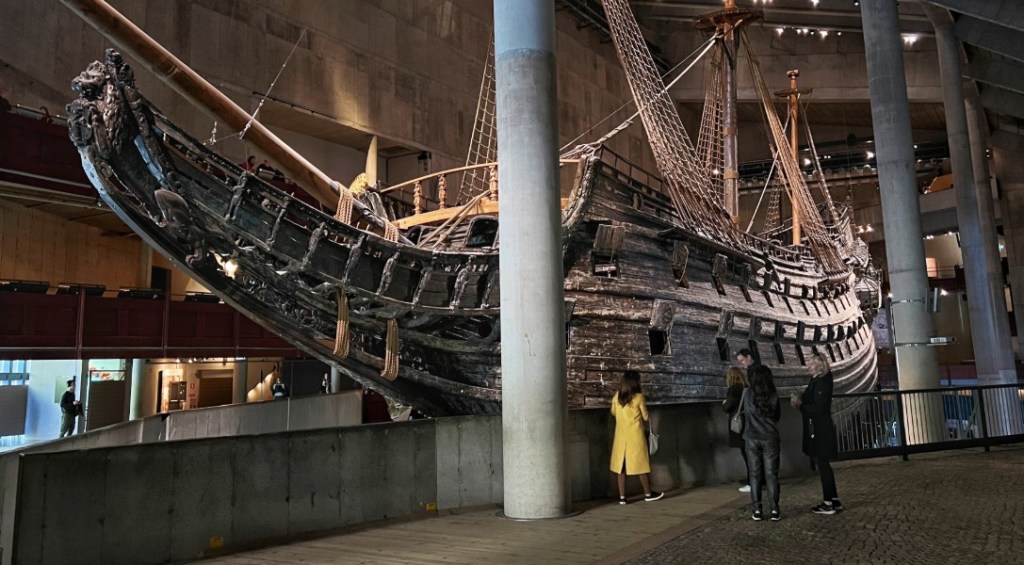 Small people besie the big Vasa Warship in the Vasa Museum.